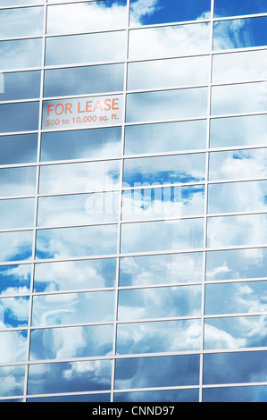 Sky and Clouds Reflected in Building Windows with For Lease Sign Stock Photo