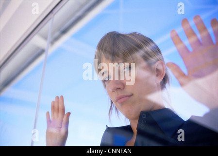 Woman peering in through glass window Stock Photo