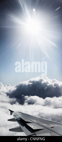 Airplane wing flying over clouds Stock Photo
