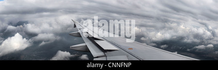 Airplane wing flying over clouds Stock Photo