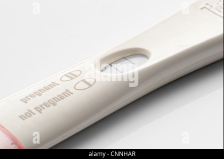 A white pregnancy test stick with a pink cap showing a positive result. Stock Photo