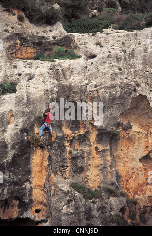 A rock climber climbing the sheer seacliffs in Gozo in Malta. Stock Photo