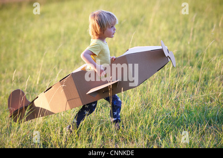 Boy flying airplane outdoors Stock Photo