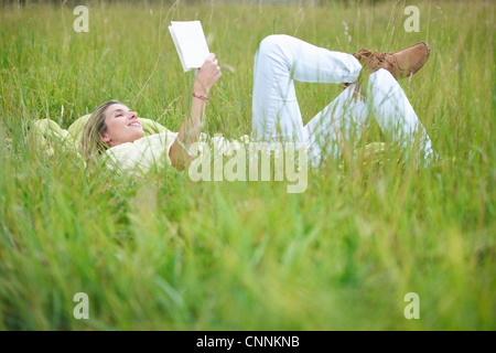 Woman reading in tall grass Stock Photo