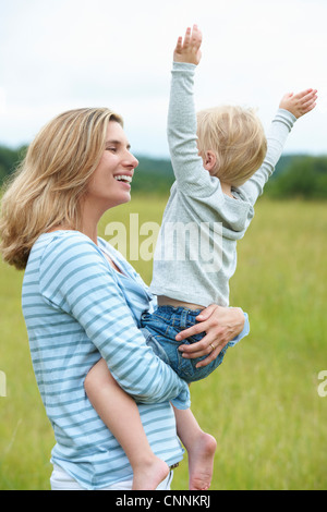 Woman holding cheering son outdoors Stock Photo