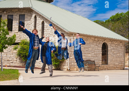 Group of highschool students celebrating their graduation by jumping and throwing caps Stock Photo