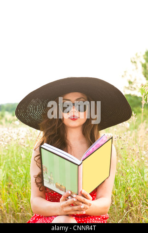 Woman Reading Book in Field Stock Photo