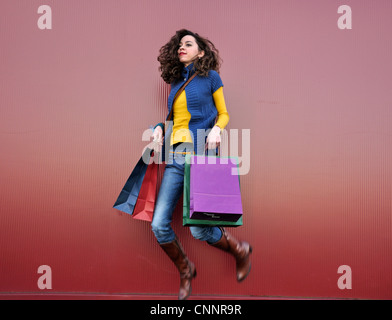 Young woman outdoors jumping with shopping bags Stock Photo