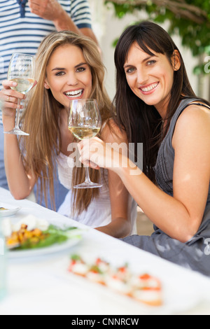 Friends having wine at table outdoors Stock Photo
