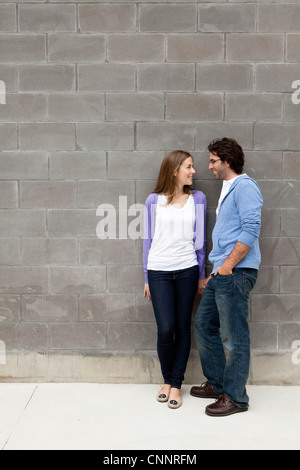 Young Couple Standing in front of Stone Wall Stock Photo