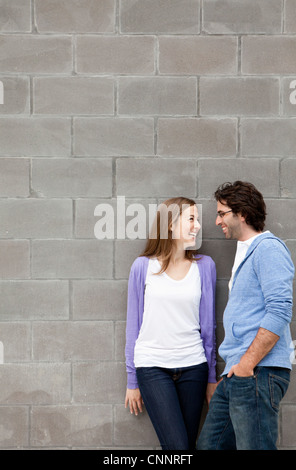 Young Couple Standing in front of Stone Wall Stock Photo