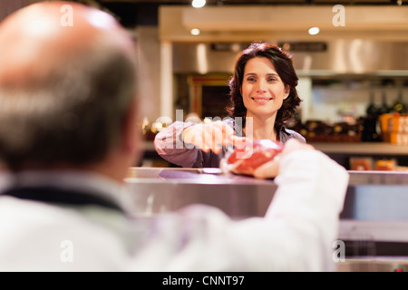 Woman buying meat from butcher Stock Photo