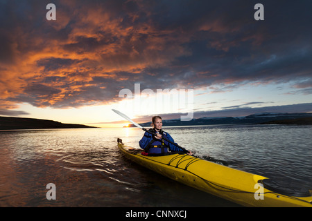 Woman kayaking in still lake Stock Photo