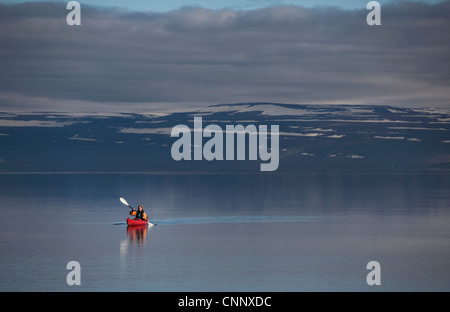 Woman kayaking in still lake Stock Photo