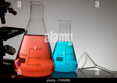 research microscope and laboratory bottles with colored liquid Stock Photo