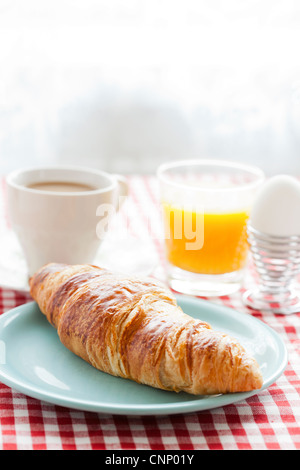 Croissant, cafe au lait, orange juice and an egg for healthy breakfast Stock Photo