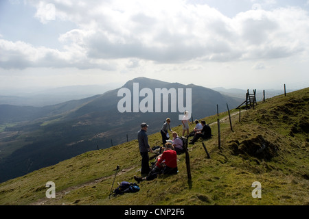 Group of ramblers resting on the Nantlle Ridge with Moel Hebog in the distance in Snowdonia in North Wales Stock Photo