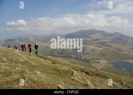 Group of ramblers walking on the Nantlle Ridge with Snowdon in the distance in Snowdonia in North Wales Stock Photo