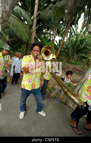 trombone player during buddhist monk ordination ceremony,pong pang temple,bank of Mae Klong River,Amphawa,Samut Sakhon,thailand Stock Photo