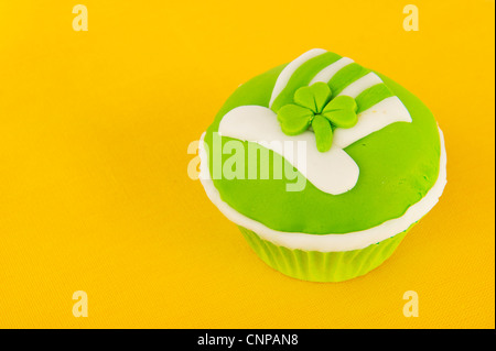 Green cup cake on yellow for St. Patricks day Stock Photo
