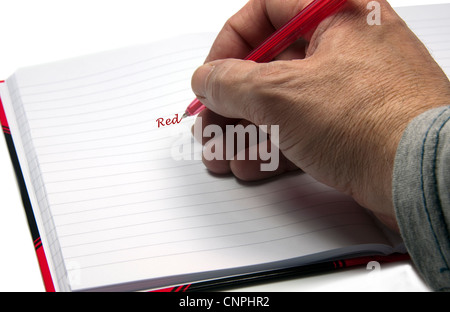 hand with a pen writing red Stock Photo