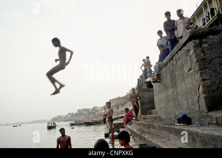Indian boy jumping on the Ganges river at the ancient Indian city of Benares (Varanasi), Uttar Pradesh, India. Stock Photo