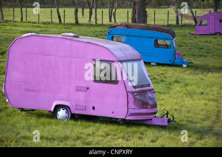 Brightly painted touring and static caravans on abandoned site called Broadsview caravans Stock Photo