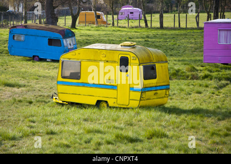 Brightly painted touring and static caravans on abandoned site called Broadsview caravans Stock Photo