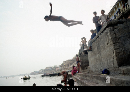Indian boy jumping on the Ganges river at the ancient Indian city of Benares (Varanasi), Uttar Pradesh, India. Stock Photo