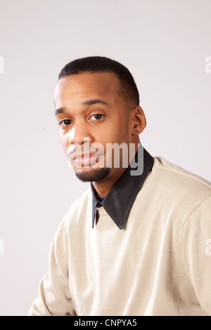 Handsome young black man with pensive expression looking at the camera Stock Photo