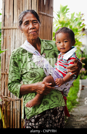 A lovely Balinese grandmother and child seen in the rice terraces of Ubud, Bali, Indonesia. Stock Photo