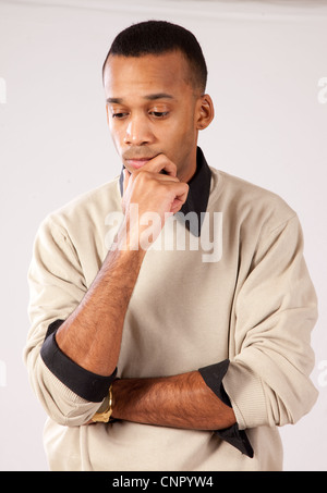 Handsome young black man with pensive expression and hands on his chin, looking pensive and thoughtful Stock Photo