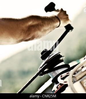 Sailor pulling rope, outdoor activities, sailboat sport race, man in action Stock Photo