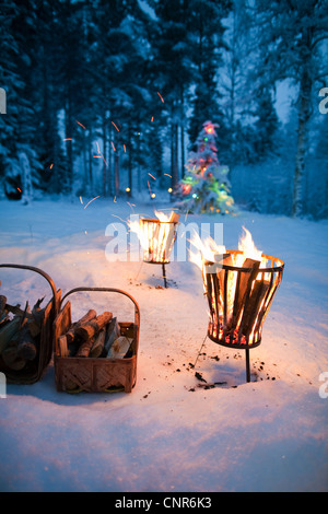 Fires in pits in snowy field Stock Photo