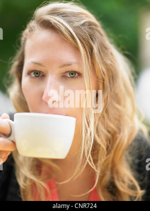 Woman having coffee at sidewalk cafe Stock Photo
