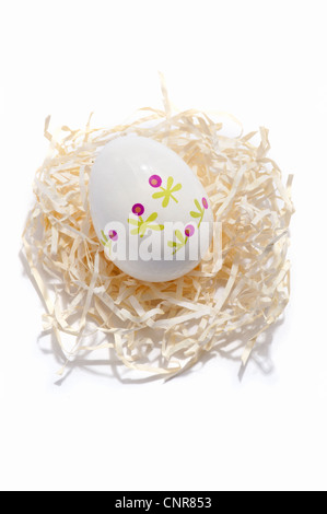 A decorated Easter egg on a paper straw nest Stock Photo