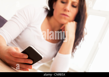 Portrait of a woman seriously reading a text message