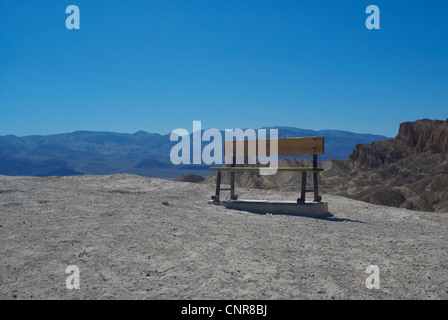 Bench on dirt path in mountains Stock Photo