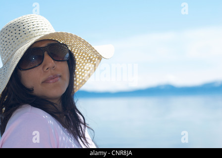 Woman wearing sunhat by lake Stock Photo
