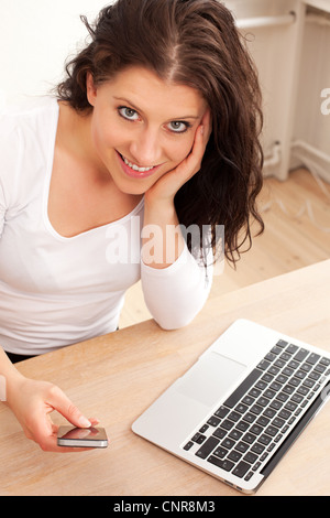 Portrait of a smiling woman texting on her cellphone Stock Photo