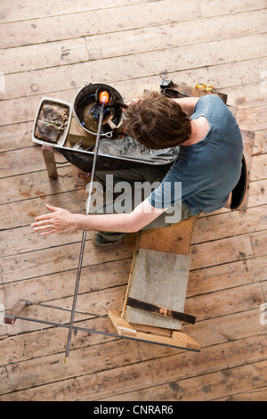 Glassblower shaping hot glass Stock Photo