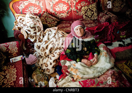 The old lady of Awarta, who sleeps only with her photos of martyrs., the old lady in her bed, in the middle of the rom. Stock Photo