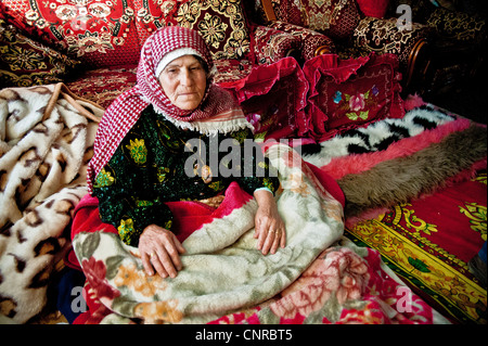 The old lady of Awarta, who sleeps only with her photos of martyrs., the old lady in her bed, in the middle of the rom. Stock Photo