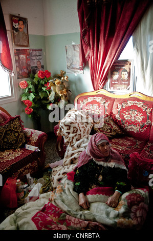 The old lady of Awarta, who sleeps only with her photos of martyrs., The old lady in her bed, in the middle of the room. Stock Photo