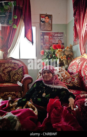 The old lady of Awarta, who sleeps only with her photos of martyrs., the old lady in her bed, in the middle of the rom. Stock Photo