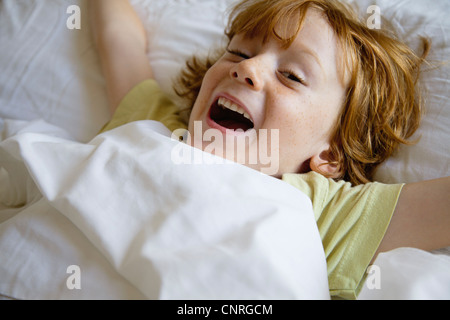 Boy lying in bed Stock Photo