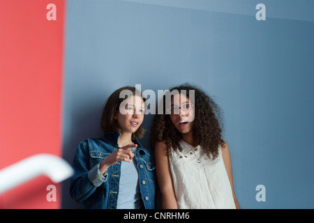 Young women gossiping together in hall Stock Photo