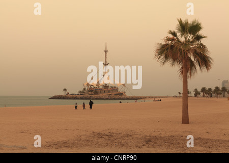 A beach in Kuwait City with the Marina Waves building in the background Stock Photo