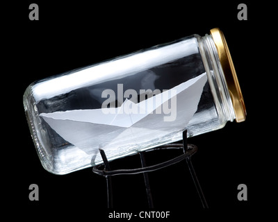 Paper ship in the jar on a black background Stock Photo
