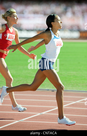 Female runner crossing finish line in race Stock Photo
